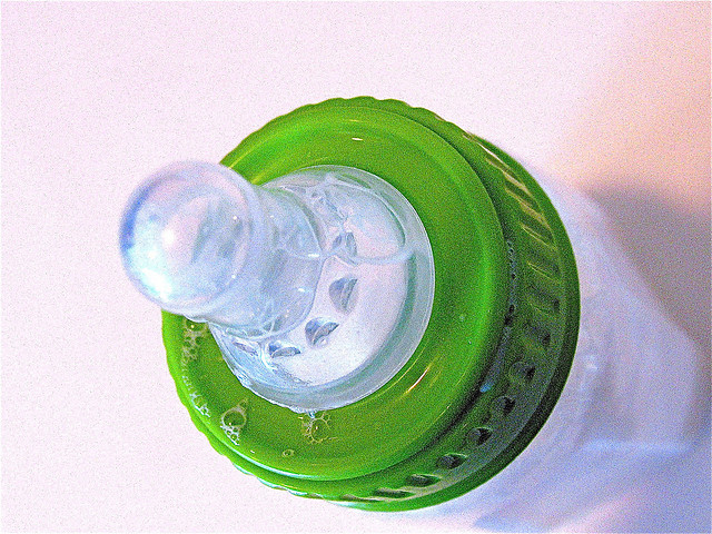 plastic baby bottle with green ring